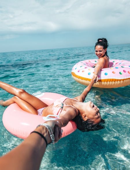 two-women-with-floats-enjoying-the-sea